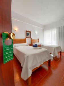sypialnia z 2 łóżkami z białą pościelą w obiekcie Termas da Sulfurea w mieście Cabeço de Vide