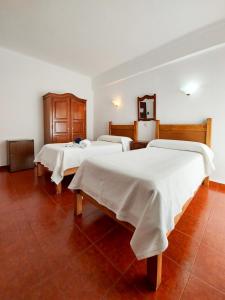 a room with three beds with white blankets on them at Termas da Sulfurea in Cabeço de Vide