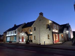 um grupo de edifícios em uma rua da cidade à noite em Ballyliffin TownHouse Boutique Hotel em Ballyliffin