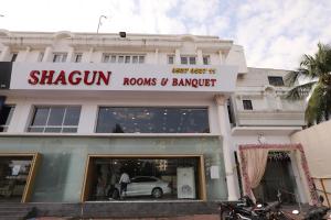 una tienda frente a un edificio con un coche en la ventana en Hotel Shagun Rooms & Banquet, Surat, en Surat