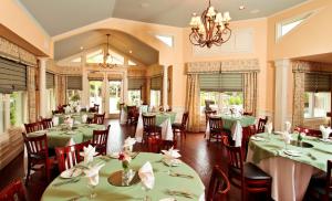 un comedor con mesas verdes y sillas en The Sanford House Inn & Spa en Arlington