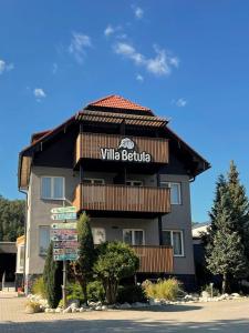a building with a sign for a wine bottle at Villa Betula Resort & Camping in Žiar