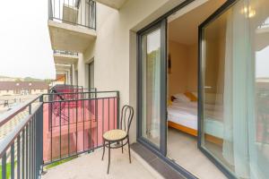 a balcony with a bed and a table and a chair at APT Nadmorskie - Spokojne in Kołobrzeg