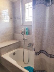 a bathroom with a bath tub with a shower at My village home in Ioannina