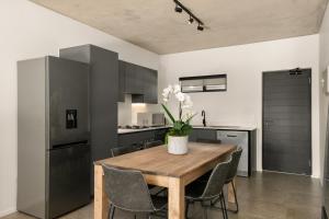 uma cozinha e sala de jantar com uma mesa de madeira e cadeiras em Hyde Park House Apartments em Joanesburgo