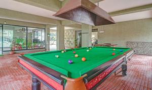 a pool table with balls on it in a room at Treebo Trend Aquamarine Arpora in Arpora