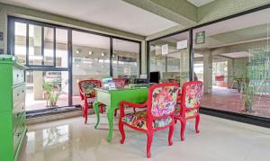 a dining room with a green table and four chairs at Treebo Trend Aquamarine Arpora in Arpora