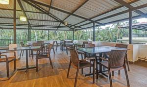 a restaurant with tables and chairs in a room at Treebo Trend Aquamarine Arpora in Arpora