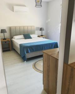 ein Schlafzimmer mit einem Bett mit einer blauen Decke in der Unterkunft Nefes evleri in Demre
