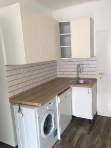 a kitchen with a washing machine and a sink at Cuki Apartmanok in Dombóvár