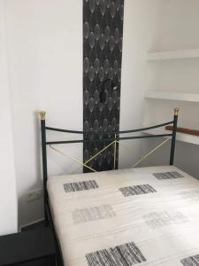 a bedroom with a bed with a black head board at Cuki Apartmanok in Dombóvár