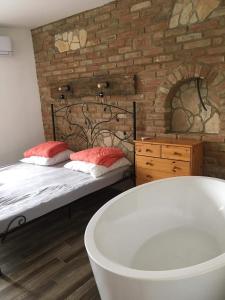 a bathroom with a bed and a bath tub at Cuki Apartmanok in Dombóvár