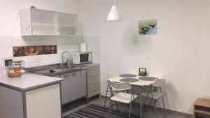 a small kitchen with a table and chairs in it at Cuki Apartmanok in Dombóvár