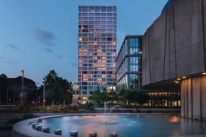 ein Gebäude mit einem Brunnen vor einem Gebäude in der Unterkunft Mövenpick Hotel Basel in Basel