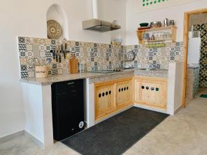 a kitchen with a counter and a black refrigerator at Casa Lucía in Sidi Ifni +17 photos