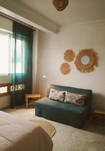 a bedroom with a couch and mirrors on the wall at Casa Lucía in Sidi Ifni