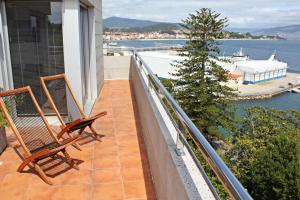 twee stoelen op een balkon met uitzicht op het water bij Precioso apartamento, espectaculares vistas. in Cangas de Morrazo