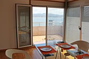 een kamer met 2 tafels en stoelen en een groot raam bij Precioso apartamento, espectaculares vistas. in Cangas de Morrazo