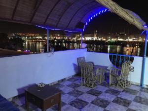 a patio with chairs and a table with a view of the water at Nubian Paradise in Aswan