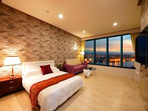 um quarto com uma cama grande e uma parede de tijolos em 85 Season em Kaohsiung