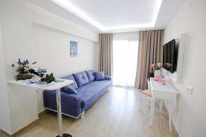 a living room with a blue couch and a tv at Princess Kinli Suites Hotel in Marmaris