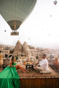 a group of people sitting around a table with a hot air balloon at Sultan Cave Suites in Goreme