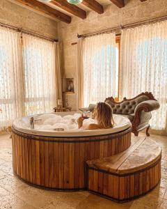 a woman sitting in a hot tub in a room at Sultan Cave Suites in Göreme
