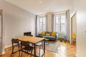 ein Wohnzimmer mit Tisch und Couch in der Unterkunft DIFY Le Belize - Bellecour in Lyon