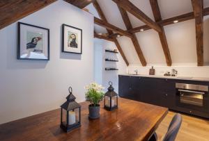 a dining room with a wooden table and a kitchen at Løðupakkhúsið - Historical Warehouse - Top Floor in Sørvágur