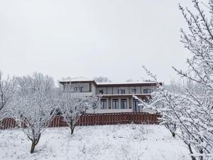 a house with a fence in the snow at Pensiunea Emelys in Iaşi
