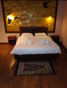 a bedroom with a bed with white sheets and a painting at Ostrella Hotel - Luxury rooms in Mýtikas