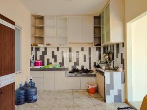 a kitchen with white cabinets and a white refrigerator at La Tana Hotel in Bagongsabrangan
