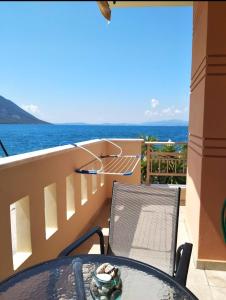 a table and chairs on a balcony with a view of the ocean at Ostrella Hotel - Luxury rooms in Mýtikas