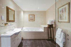 une salle de bain blanche avec une baignoire et un lavabo dans l'établissement Beamish Hall Hotel, BW Premier Collection, à Stanley 67 autres photos