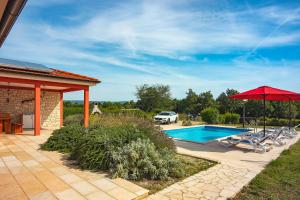 uma casa com piscina e guarda-sol vermelho em Villa Kata em Krnica