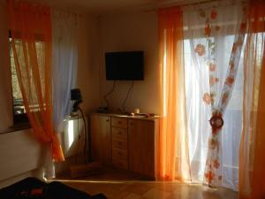 Habitación con cortinas y tocador con TV. en Winzerhäuschen Kern, en Fehring