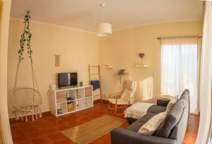 a living room with a couch and a tv at O DRAGOEIRO da Madalena! in Porto Santo