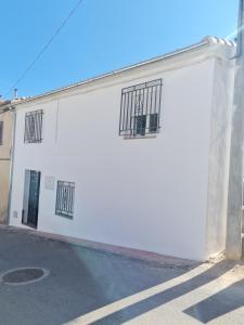 un edificio blanco con 2 ventanas y una calle en Mirador de Cárchel, en Carchel