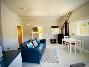 a living room with a blue couch and a table at Kingfisher Lodge in Froggatt