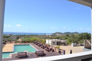 vistas a la piscina desde el balcón de una casa en Ponta View Hotel en Ponta do Ouro