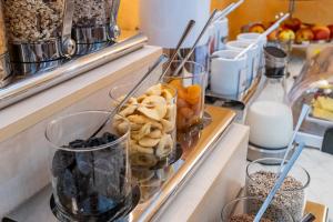 una línea de buffet con aperitivos y vasos de leche en Hotel am Marschiertor, en Aachen
