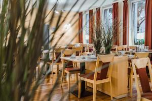 une rangée de tables et de chaises dans un restaurant dans l'établissement Hotel am Marschiertor, à Aix-la-Chapelle