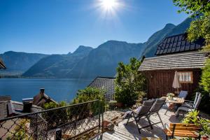 a patio with a view of a lake and mountains at Historic Lakeview Apartments Hallstatt in Hallstatt