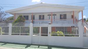 una recinzione bianca di fronte a una casa bianca di Apartamento Miss Brigida a San Andrés