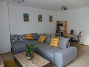 a living room with a gray couch and a table at Exclusive kuschelige Wohnung im Herzen FrankensEuropa in Gaukönigshofen