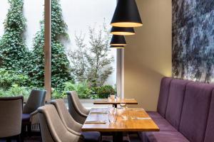 a restaurant with a table and chairs and a large window at Botanique Hotel Prague in Prague