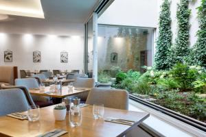 a restaurant with tables and chairs and a large window at Botanique Hotel Prague in Prague