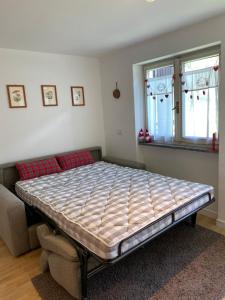 uma cama num quarto com um sofá e janela em Chasse neige - Cervinia em Breuil-Cervinia