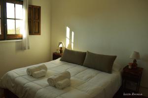 a bedroom with a large white bed with two pillows at Posada Las Vertientes in Copina