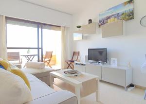 マルベーリャにあるBeachfront Studio Apartment Marbellaのリビングルーム(ソファ、テレビ付)
